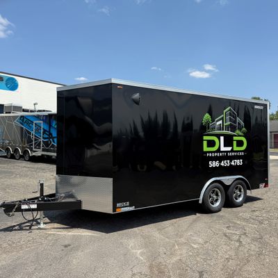 A commercial trailer with a custom vinyl wrap with green logos and design