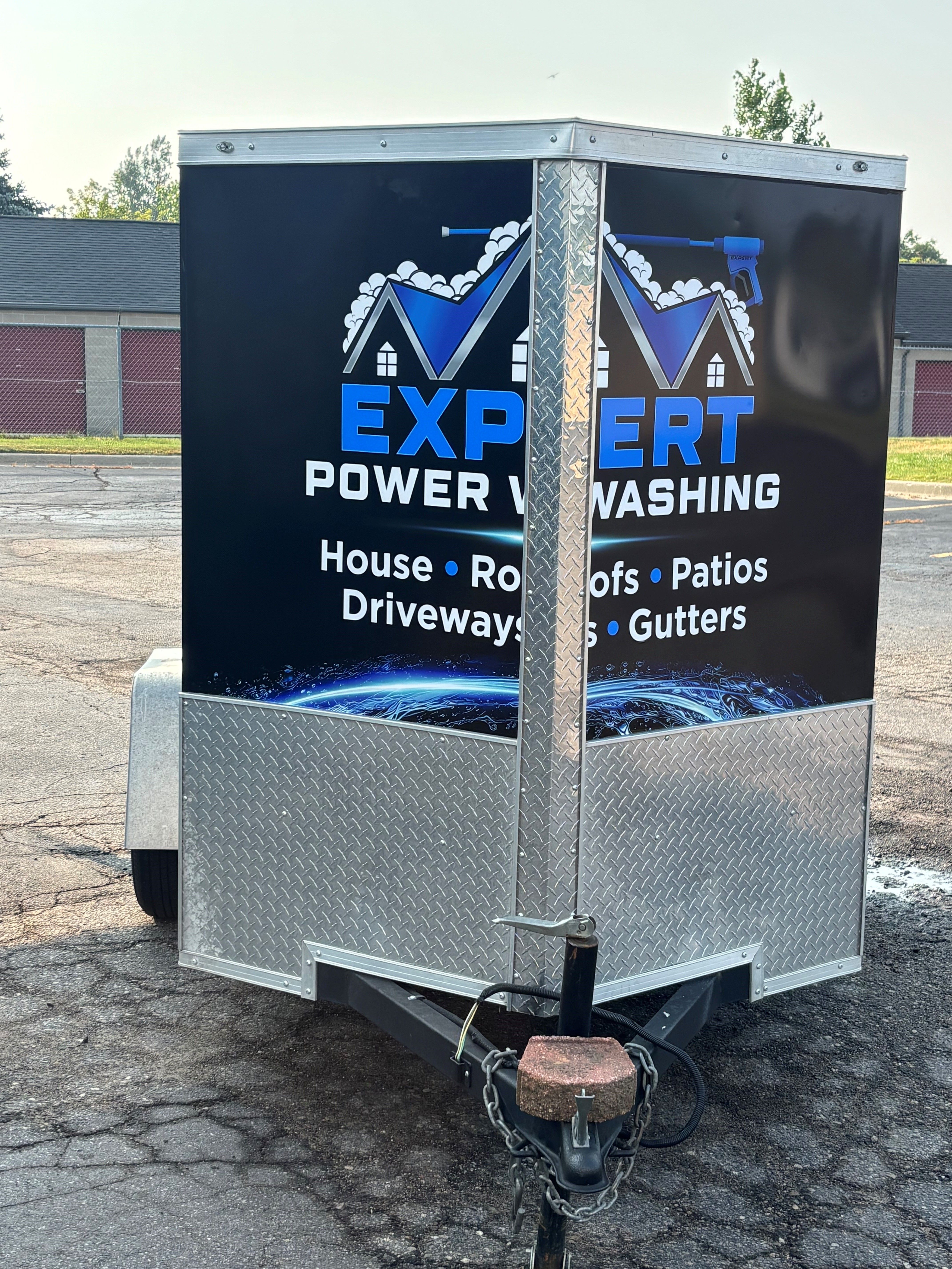 A commercial trailer with a custom vinyl wrap with blue and white text and logo