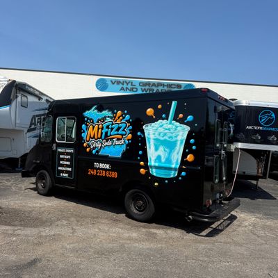 A commercial food truck with a custom vinyl wrap with text and logos.