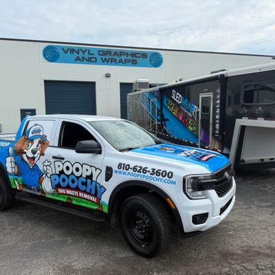 A commercial work truck with a custom vinyl wrap with blue and white text and dog logo.