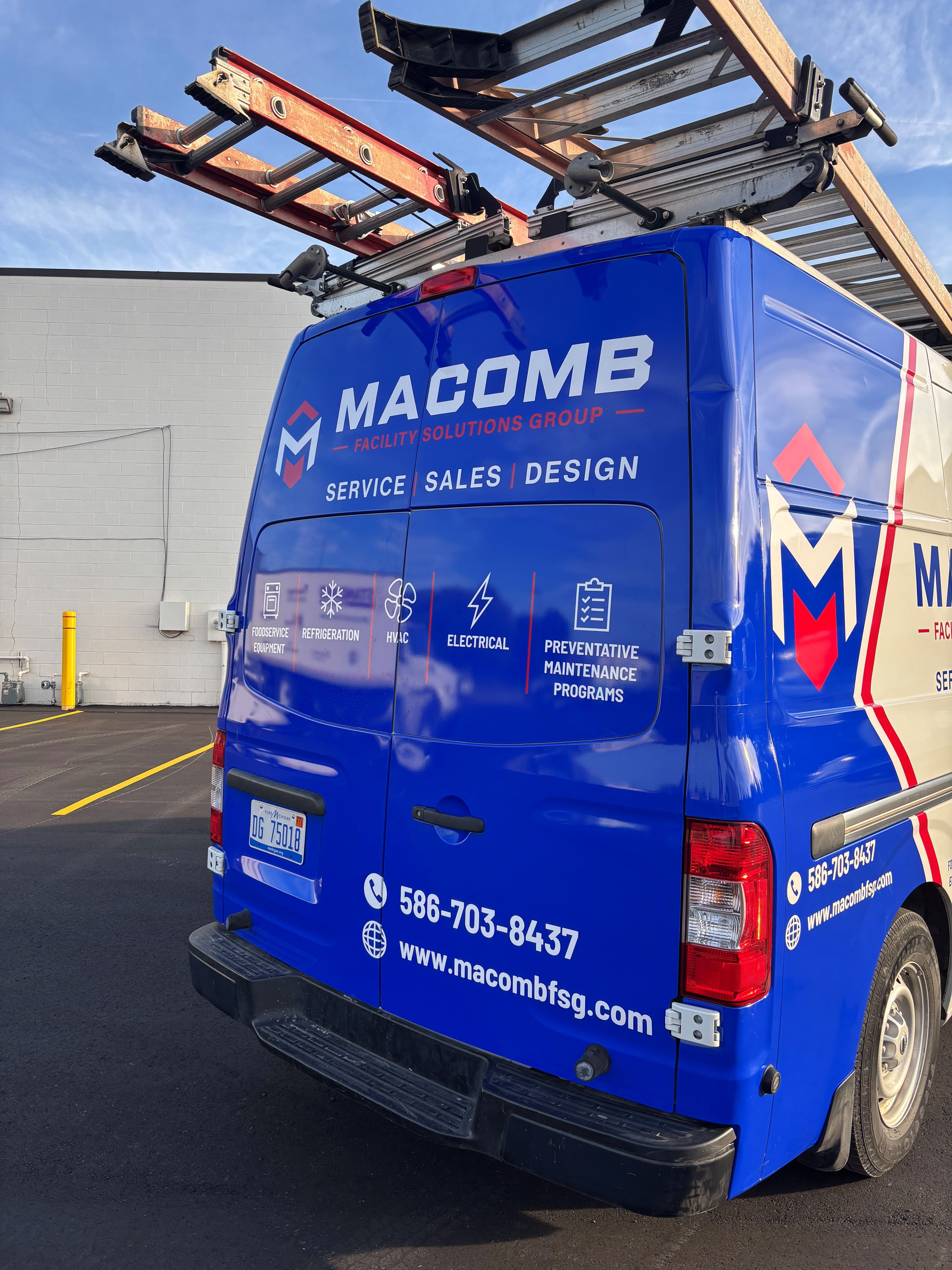 A commercial work van with a custom vinyl wrap with blue, white, and red text and logos