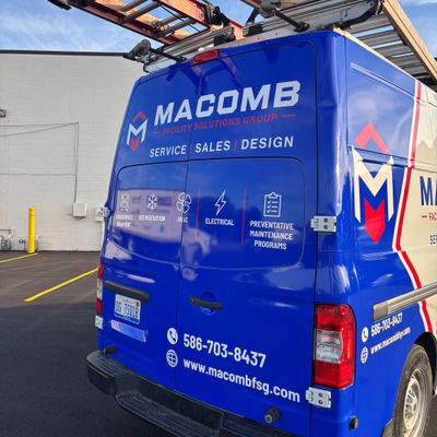 A commercial work van with a custom vinyl wrap with blue, white, and red text and logos