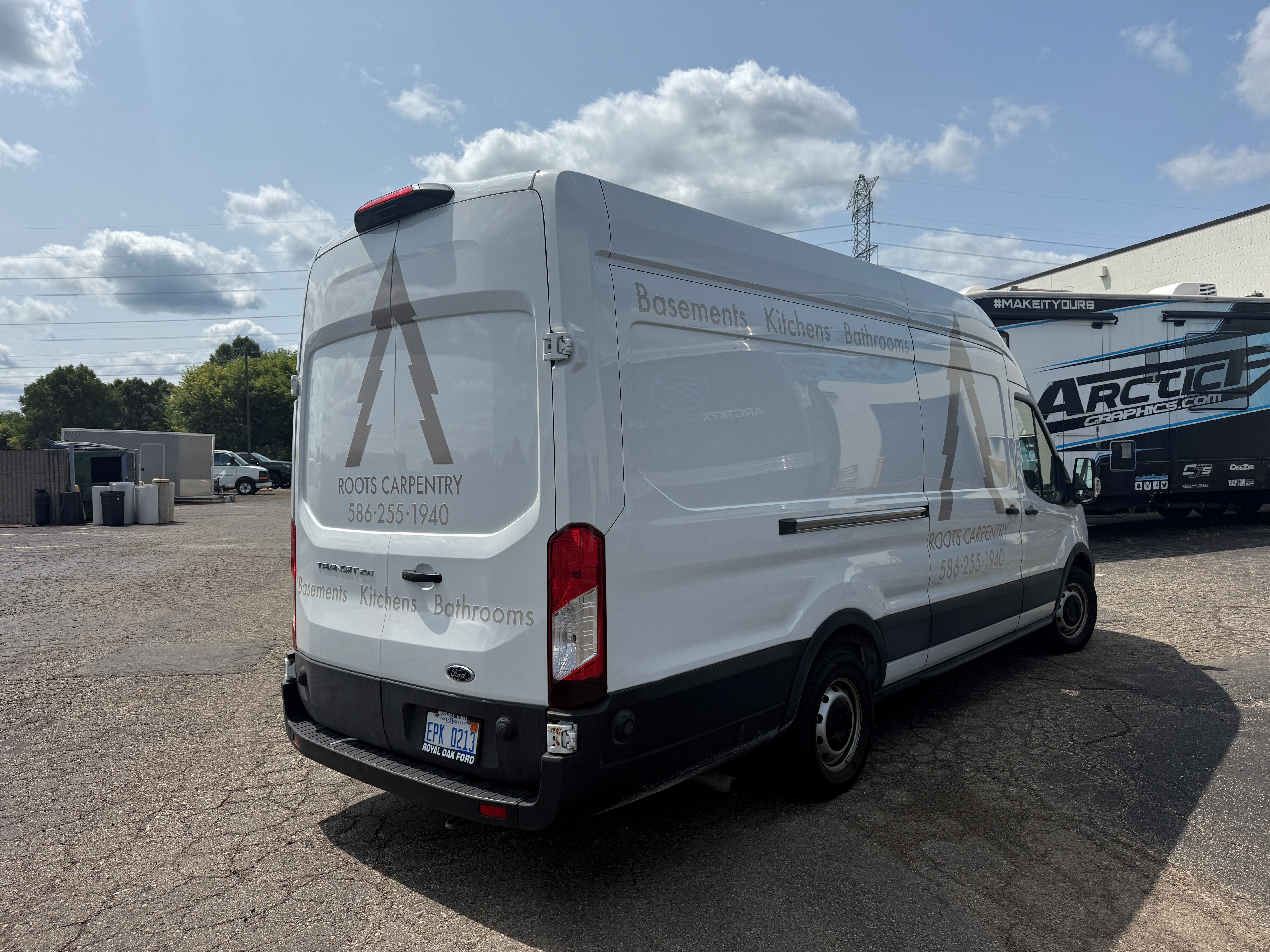 A commercial work van with a custom vinyl wrap with tan text and logo.