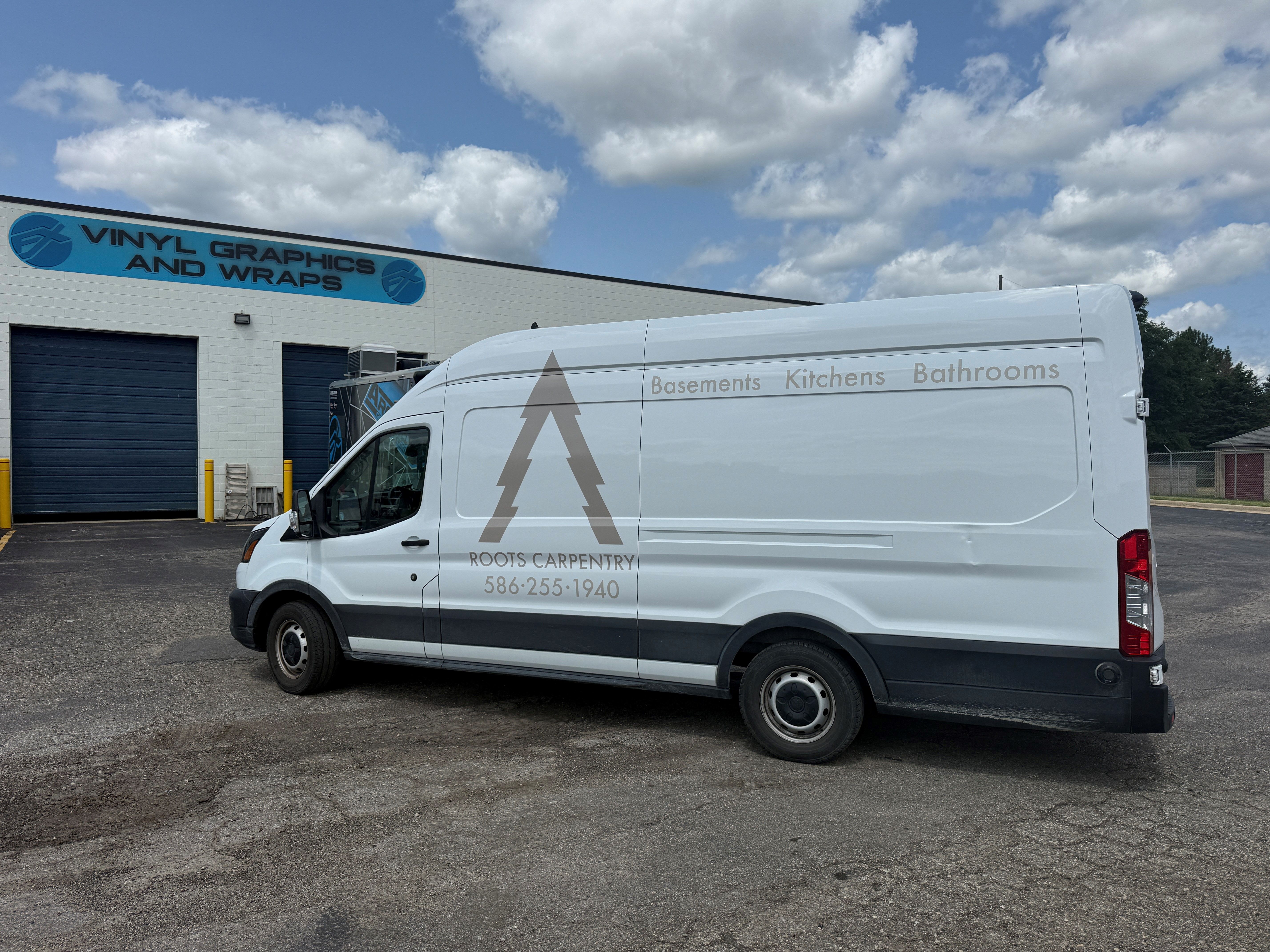 A commercial work van with a custom vinyl wrap with tan text and logo.
