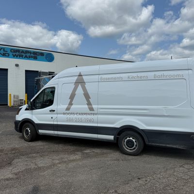 A commercial work van with a custom vinyl wrap with tan text and logo.
