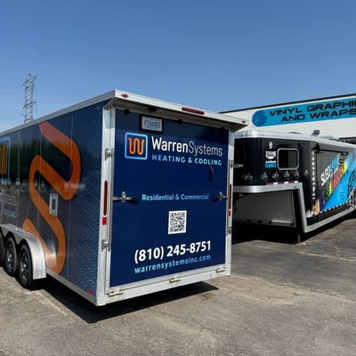 A commercial trailer with a custom vinyl wrap with white, blue, and orange logos.