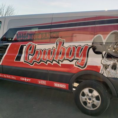 A commercial work van with a custom vinyl wrap with white, red, and black logos and text with a cowboy UFC design
