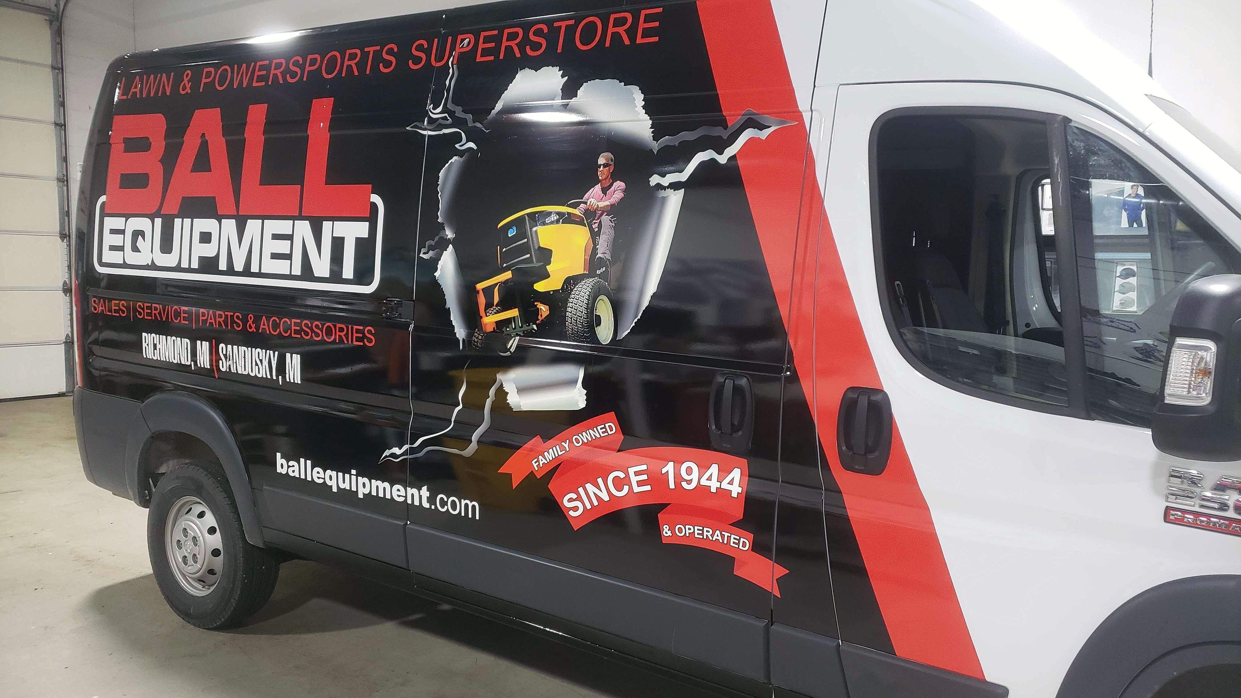 A commercial work van with a custom vinyl wrap for Ball Equipment colored red white and black