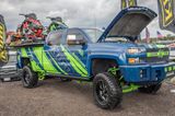 A commercial work truck with a custom vinyl wrap with lime green, gray, and blue logos and text with a simple grunge design