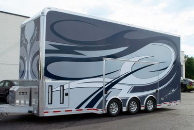 A trailer with a custom decorative tribal vinyl wrap with white, navy and black lines and swirls.