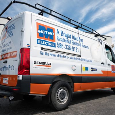 A commercial work van with a custom vinyl wrap with white, blue, black and orange logos and text
